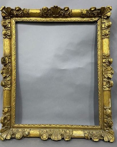 Sculpted and gilded oak frame with flower...