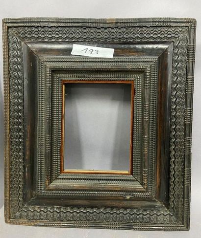 Blackened moulded wooden frame with an upside-down...