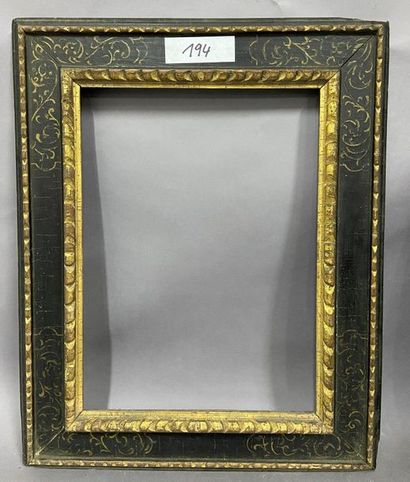 Carved and gilded wood frame with a black...