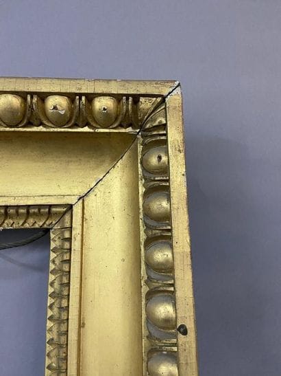 Carved and gilded wooden frame with a frieze...