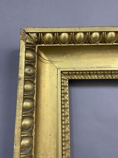 Carved and gilded wooden frame with a frieze...