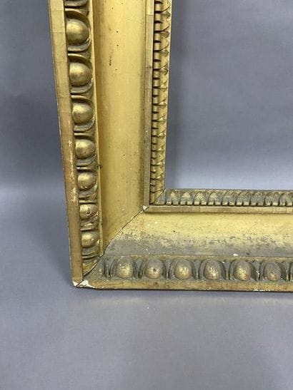 Carved and gilded wooden frame with a frieze...