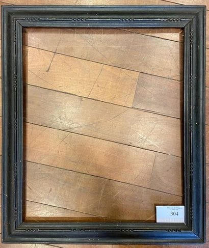 Cadre en bois, sculpté et noirci à profil...