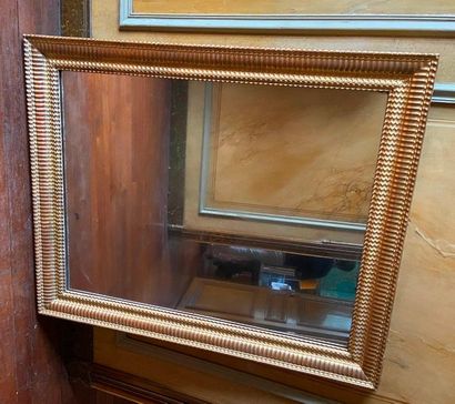 Miroir en stuc et bois doré à décor de godrons,...