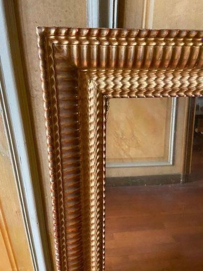 Miroir en stuc et bois doré à décor de godrons,...