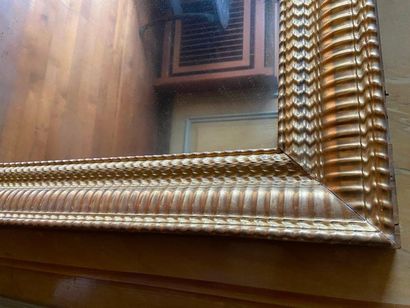 Miroir en stuc et bois doré à décor de godrons,...