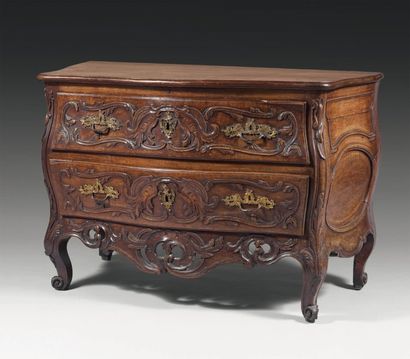 Commode galbée en noyer richement sculpté...