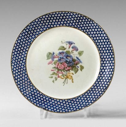 SÈVRES
Assiette à décor polychrome au centre...