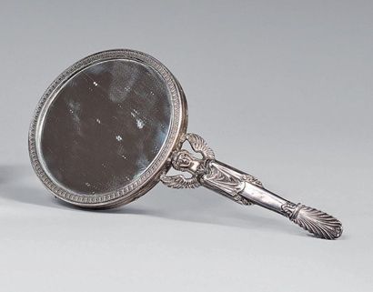 Circular hand mirror in a silver frame, the...