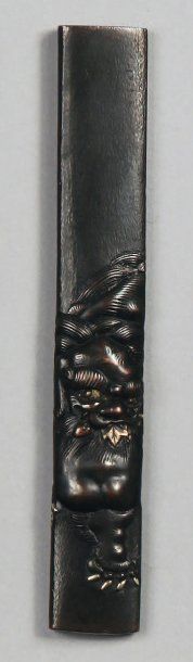 Kozuka en shakudo décoré en relief d'un shishi....