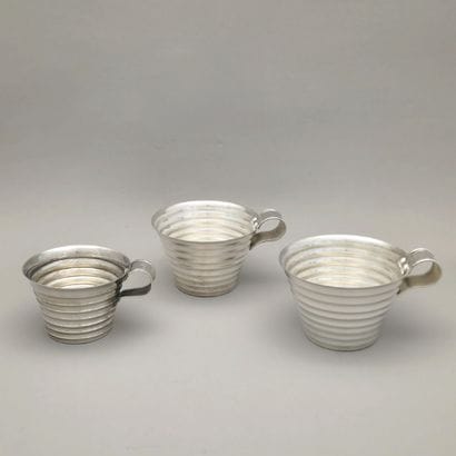 THREE MUGS Circa 1950 with fluted decoration,...