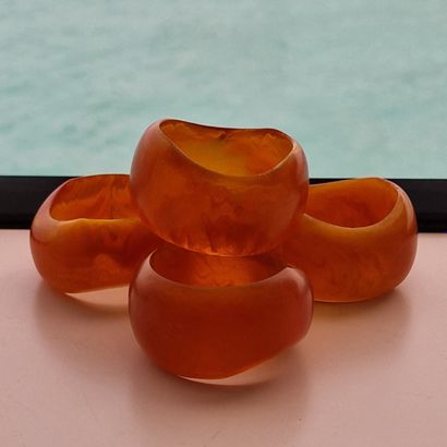 SUITE OF 12 NAPKIN RINGS IN AMBER COMPOSITION
D....