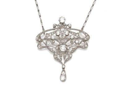 DELICAT COLLIER holding a pendant brooch...
