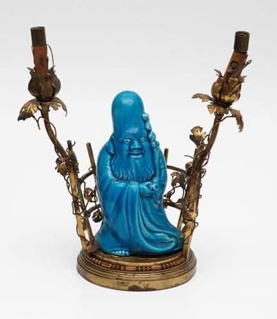 Lampe en porcelaine bleue figurant un sage,...