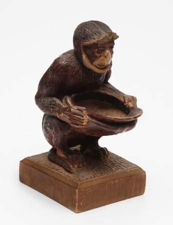 Singe tenant une coupe en bois polychrome...