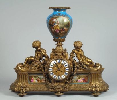 Grande pendule surmontée d'un vase flanqué...